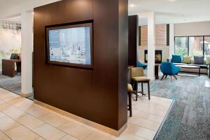 a lobby with a flat screen tv on a wall at Courtyard by Marriott Tucson Williams Centre in Tucson