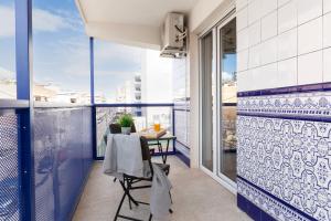 a balcony with blue and white tiles and a table at SoleOle in Playa de Gandia