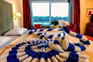 two beds in a hotel room with towels on them at Nile cruise every Monday 4 night Luxor Aswan -3nights every Friday Aswan Luxor in Aswan