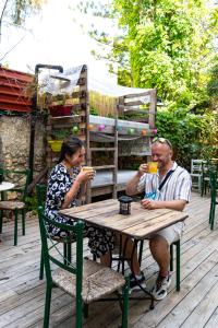 un hombre y una mujer sentados en una mesa con bebidas en Chania Hostel Youth, en La Canea