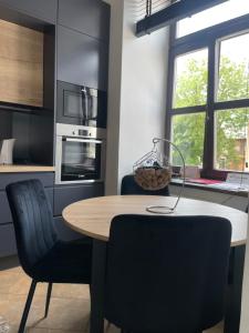 a kitchen with a wooden table and two chairs at Apartamenty Łuczkowskiego z widokiem na Stary Rynek i Studnie 1 102m2 in Chełm