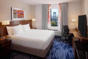 a hotel room with a bed and a desk and a window at Fairfield Inn & Suites New York Manhattan/Downtown East in New York