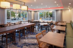 un restaurante con mesas, sillas y ventanas en Fairfield Inn & Suites New York Manhattan/Downtown East en Nueva York