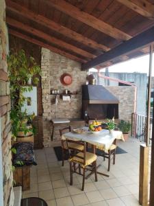 eine Terrasse mit einem Tisch, Stühlen und einem Kamin in der Unterkunft Casa Serena in Serdiana