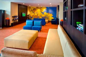 a living room with couches and blue chairs at Courtyard by Marriott Niagara Falls in Niagara Falls
