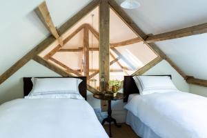 two beds in a attic room with a window at Seaves Mill in York