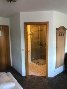 baño con ducha y puerta de cristal en Gästehaus Schwarzlofer, en Reit im Winkl