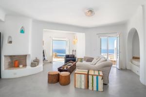 un soggiorno bianco con divano e camino di Mermaid Luxury Villas - Aquata Private pool a Fanari