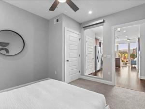 a white bedroom with a bed and a mirror at CozySuites Dream 1BR, PPG Paints Arena, Pitts in Pittsburgh