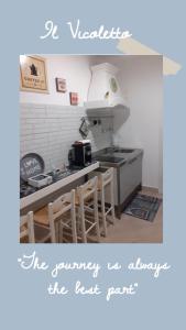 a kitchen with a sink and a counter with chairs at Il Vicoletto in Santa Marinella