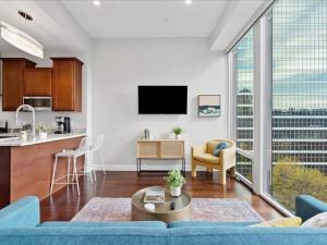 a living room with a blue couch and a kitchen at CozySuites Dream 1BR, PPG Paints Arena, Pitts in Pittsburgh