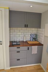 a kitchen with white cabinets and a counter top at Cottage for visiting sea, city, forest in Holm