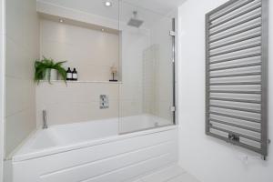 a white bathroom with a tub and a window at Aircon 2 Bedr, 3 Beds, 2 Bath Covent Garden, Subway in London