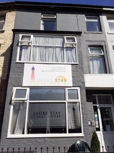 a store window of a building with a store say store stay at Shore Stay Guest House in Blackpool