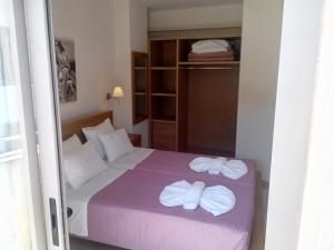 a bedroom with a bed with two towels on it at Maria Apartments in Agia Pelagia