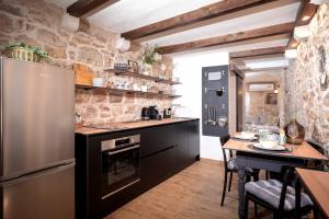 a kitchen with a stainless steel refrigerator and a table at Heritage Stone House Retreat -Free parking in Stari Grad