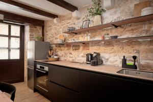 a kitchen with a sink and a refrigerator at Heritage Stone House Retreat -Free parking in Stari Grad +14 photos