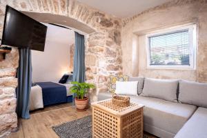 a living room with a couch and a tv at Heritage Stone House Retreat -Free parking in Stari Grad