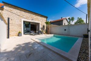a swimming pool in the backyard of a house at Stone House with pool Poeta in Pridraga