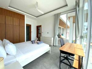 1 dormitorio con cama, escritorio y mesa en Villa Gratia Alba en Nathon Bay