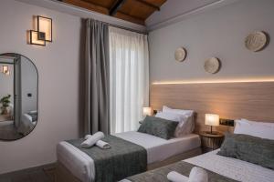 una camera d'albergo con due letti e uno specchio di Natura Hill Villa IV Sea View a Kounoupidhianá