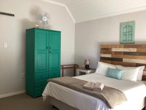 伯格威爾的住宿－Ledges Retreat，一间卧室配有绿色橱柜和一张床