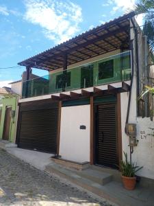 un edificio con 2 puertas de garaje y balcón en Casa Temporada Sol E Lua, en Búzios