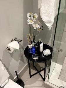 a black table with flowers on it in a bathroom at Exec Oasis @Ellipse in Midrand