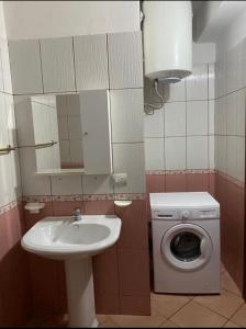 uma casa de banho com um lavatório e uma máquina de lavar roupa em Martin Apartment em Vlorë