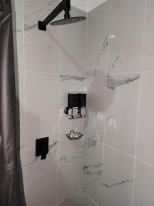 a white bathroom with a shower with marble tiles at Astoria Gated Condos in Cancún