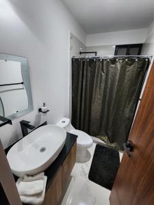 a bathroom with a sink and a toilet and a shower at Astoria Gated Condos in Cancún