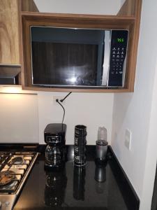 a kitchen with a microwave above a stove at Astoria Gated Condos in Cancún