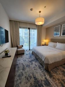 Pokój hotelowy z dużym łóżkiem i telewizorem w obiekcie The Address Residences Fujairah w Fudżajrze