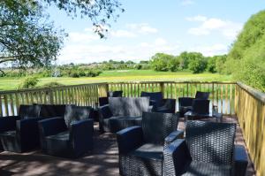 a deck with chairs and a table on a fence at River View Retreat in Offenham