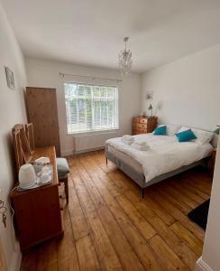 a bedroom with a large bed and a wooden floor at Seaside Rooms Gorleston in Gorleston-on-Sea