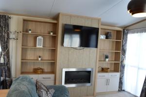 ein Wohnzimmer mit einem Flachbild-TV an der Wand in der Unterkunft River View Retreat in Offenham
