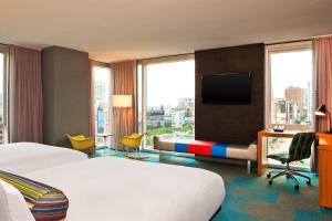 Aloft Chicago Downtown River North في شيكاغو: غرفة في الفندق بها سرير ومكتب وتلفزيون