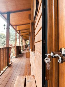 een houten deur met een handvat op een veranda bij Golden Leather Carving Studio in Leye