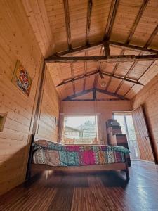 樂野村的住宿－金皮雕工作室，一张位于带大窗户的房间内的床铺