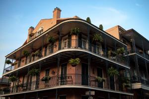 an apartment building with potted plants on the balconies at The Saint Hotel, New Orleans, French Quarter, Autograph Collection in New Orleans
