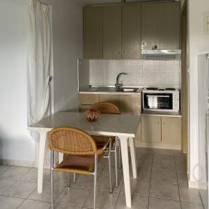 a kitchen with a table with chairs and a sink at Pansion Argo in Nea Moudania