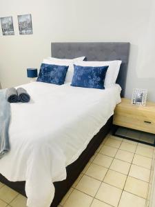 1 dormitorio con 1 cama grande con almohadas azules en The Home en Richards Bay
