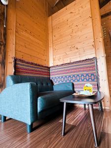 a blue couch and a table in a room at Golden Leather Carving Studio in Leye