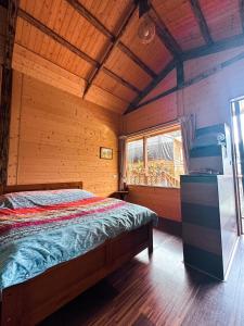 a bedroom with a bed in a wooden cabin at Golden Leather Carving Studio in Leye