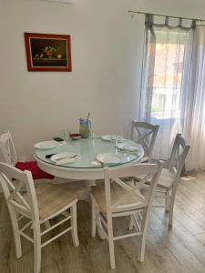 een witte tafel en stoelen in een kamer bij Apartments Villa Antony 2 in Drvenik