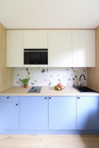 a kitchen with white cabinets and a microwave at Telimeny 31 in Krakow
