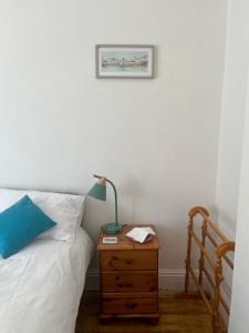 a bedroom with a bed and a lamp on a night stand at Seaside Rooms Gorleston in Gorleston-on-Sea