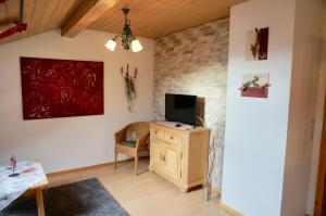 Allgäu-Moni Trauchgau في هالبليخ: غرفة معيشة مع تلفزيون على خزانة خشبية
