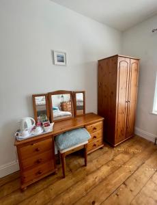 a wooden desk with a mirror and a dresser at Seaside Rooms Gorleston in Gorleston-on-Sea