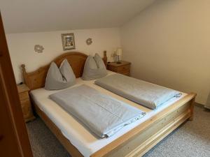 Allgäu-Moni Trauchgau في هالبليخ: غرفة نوم بسرير ذو شراشف ووسائد بيضاء